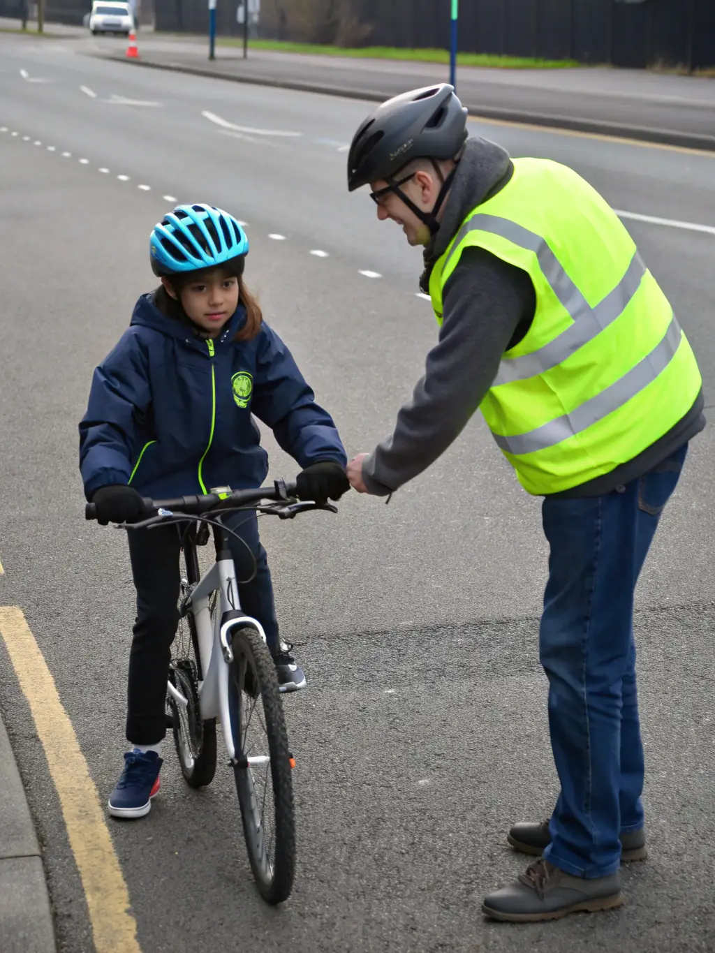 A dynamic shot of a motorcycle safety instructor demonstrating proper riding techniques to a group of students on a closed course, emphasizing the importance of safety and skill development.